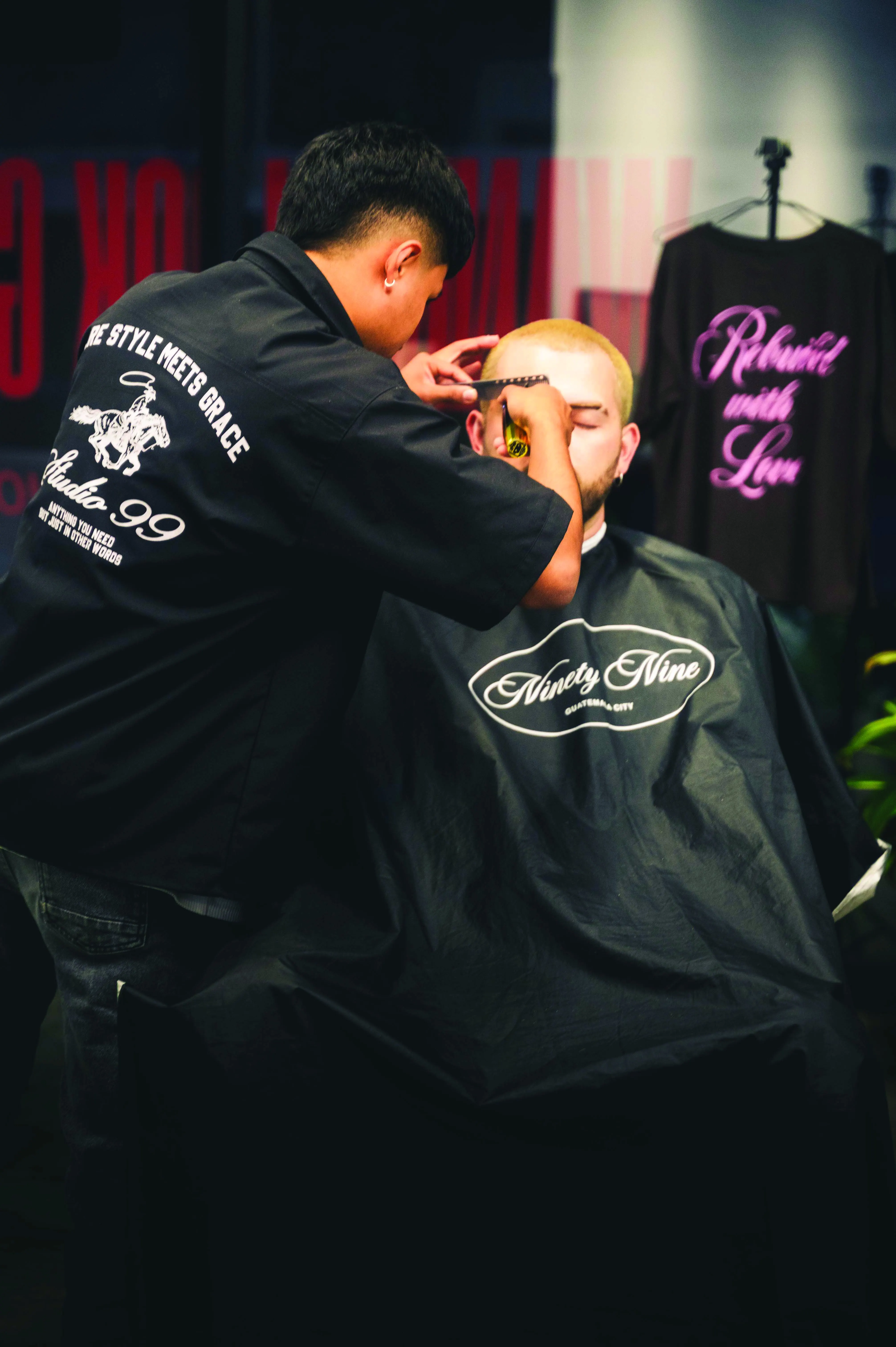 Detalle capa Ninety Nine con la playera Rebuild with Love al fondo